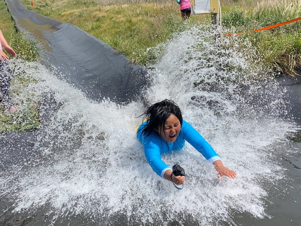 Boy splashing at end of a water slide